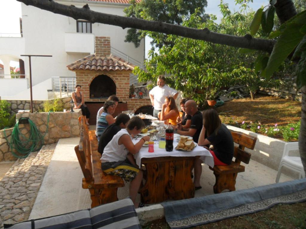 a group of people sitting at a table at Apartments Zatezalo A4+2 in Omišalj