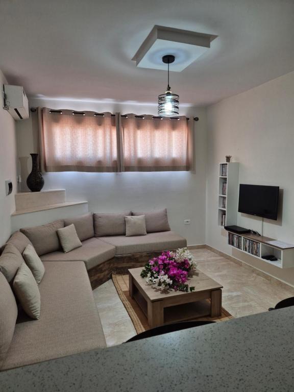 a living room with a couch and a table at Cozy Apartment in Monastir