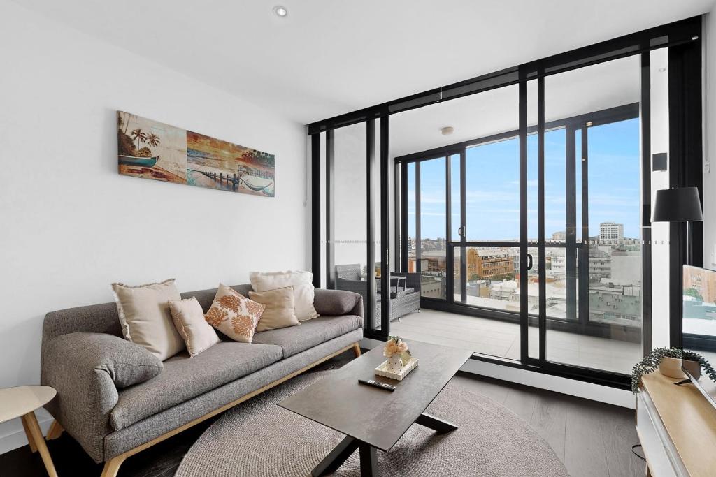 a living room with a couch and large windows at Stylish 2BR with Story Bridge & Fireworks Views in Brisbane