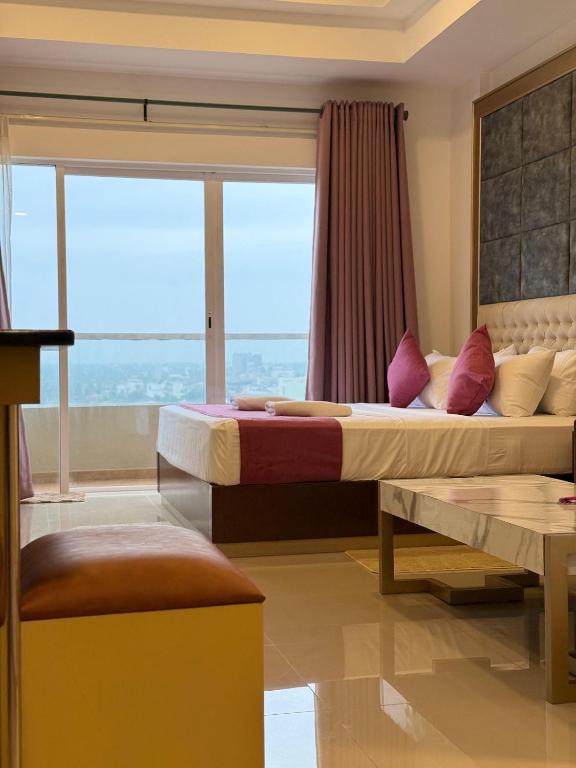 two beds in a room with a window at High Tides End Ceylon Negombo in Negombo