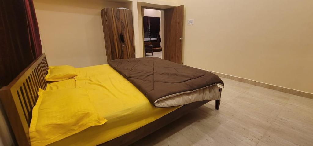 VenkatāpurにあるGolden nest farmsの黄色い毛布が掛けられたベッドのある寝室