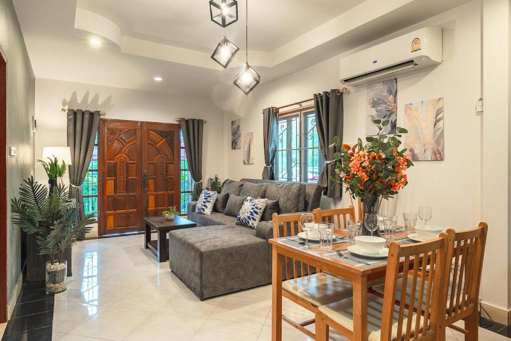 a living room with a couch and a table at Coastline Pearl Holiday Home, Bangtao Beach in Ban Thalat Choeng Thale