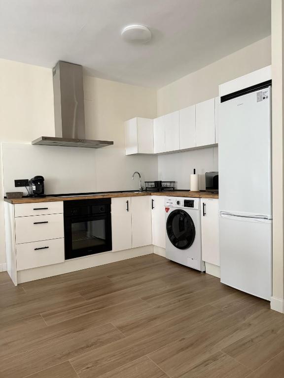 a kitchen with white cabinets and a washer and dryer at El GABINETE in Argamasilla de Alba