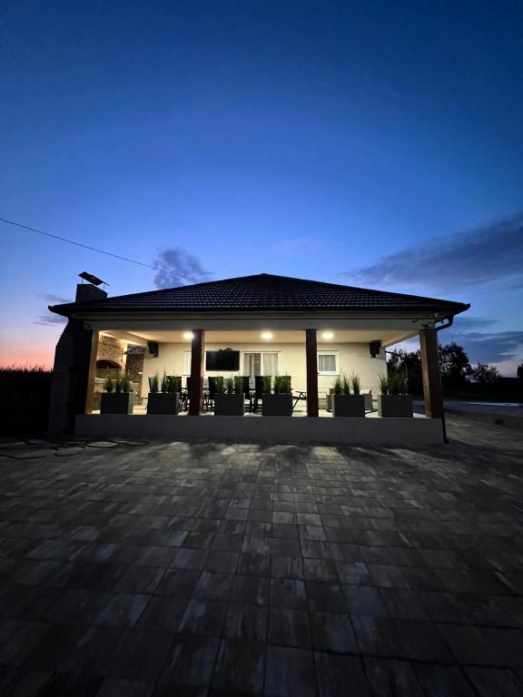 a house with a patio in the evening at Villa Star Lux Bijeljina in Bijeljina