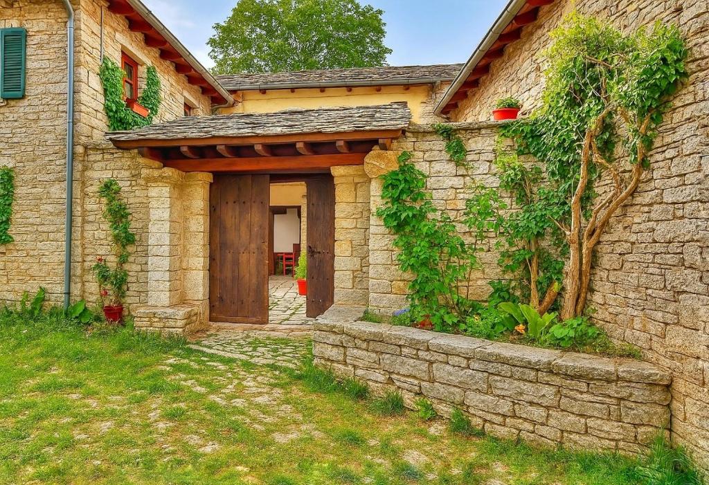 モノデンドリにあるArchontiko Rapti Stone Traditional Houseの木の扉と石の壁の石造家