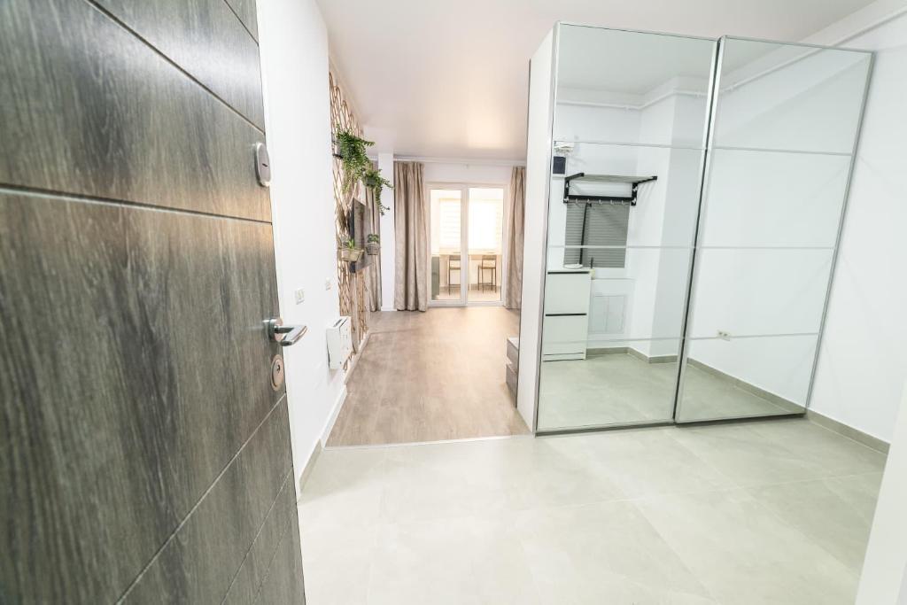 a bathroom with a glass door and a hallway at Natural Luxury Studio Central Adress Residence in Bucharest