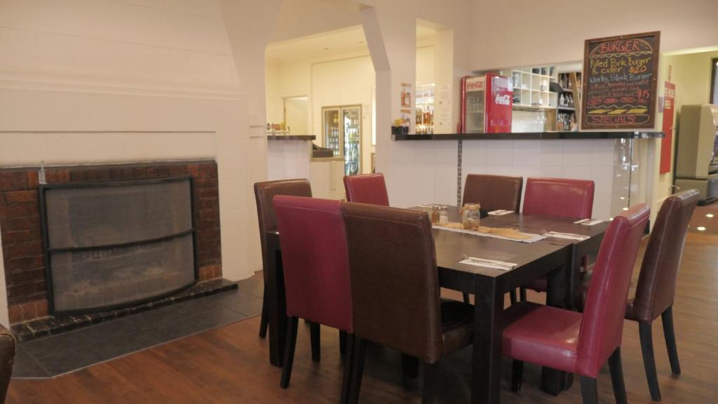 a dining room table with chairs and a coffee table at National Hotel Toowoomba in Toowoomba