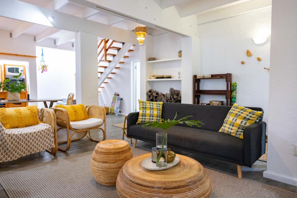a living room with a couch and a table at Onrus Island Milkwood Sanctuary in Hermanus