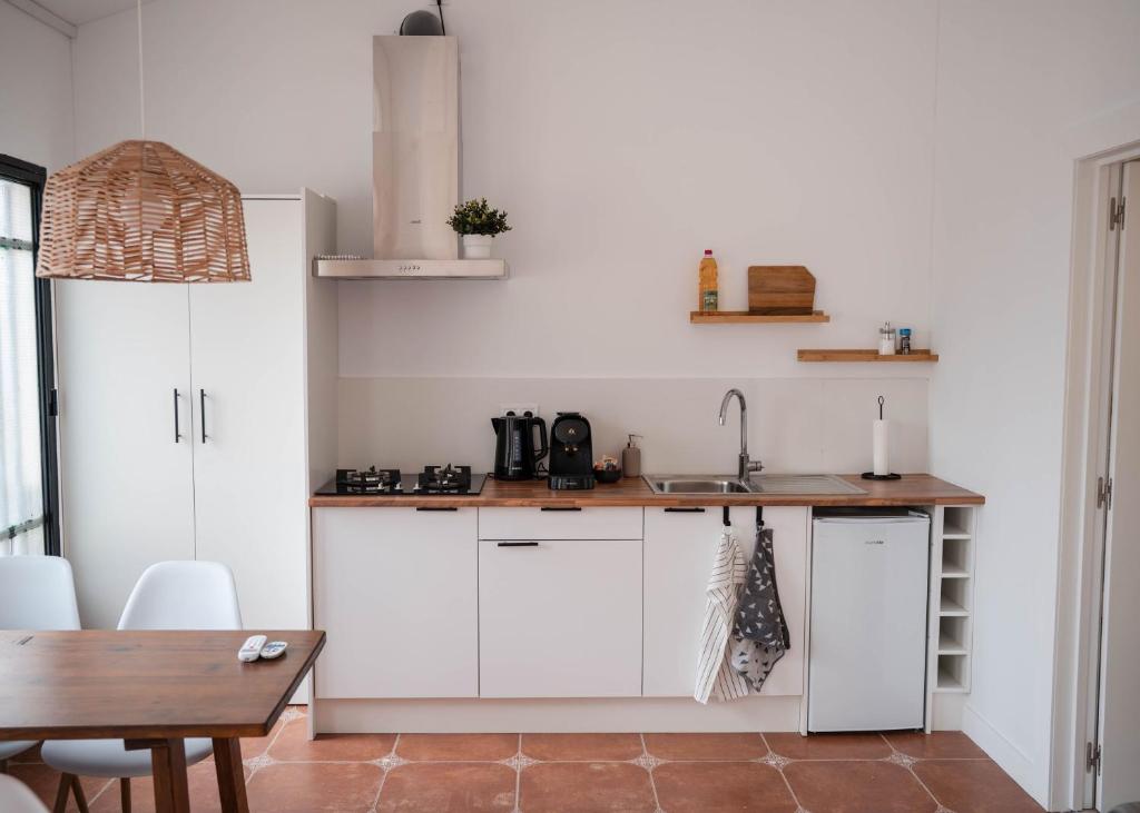 a kitchen with white cabinets and a wooden table at Apartment La casa Zamora in Totana
