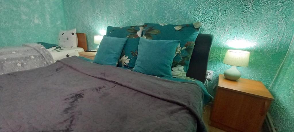 a green bedroom with a bed with blue pillows at 1 кімнатні апартаменти в гостьовому будинку in Mukacheve