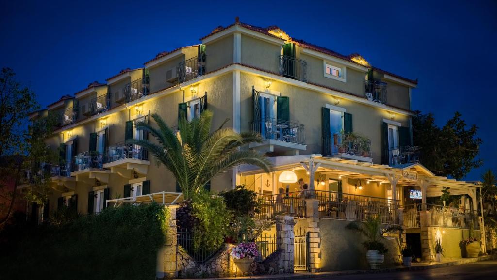 a large white building with lights on it at night at Captain's House Hotel in Skala