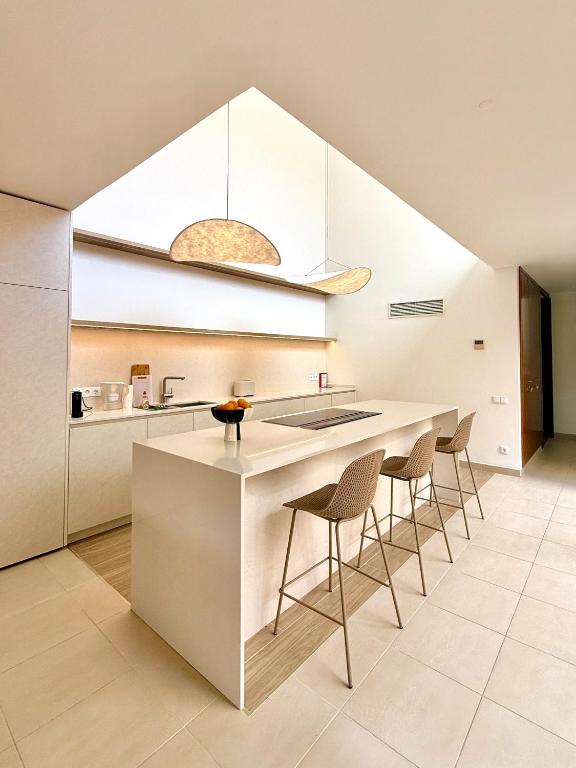 a kitchen with a white counter and stools at Salgados Premium Beach Villa 4 Suites in Guia