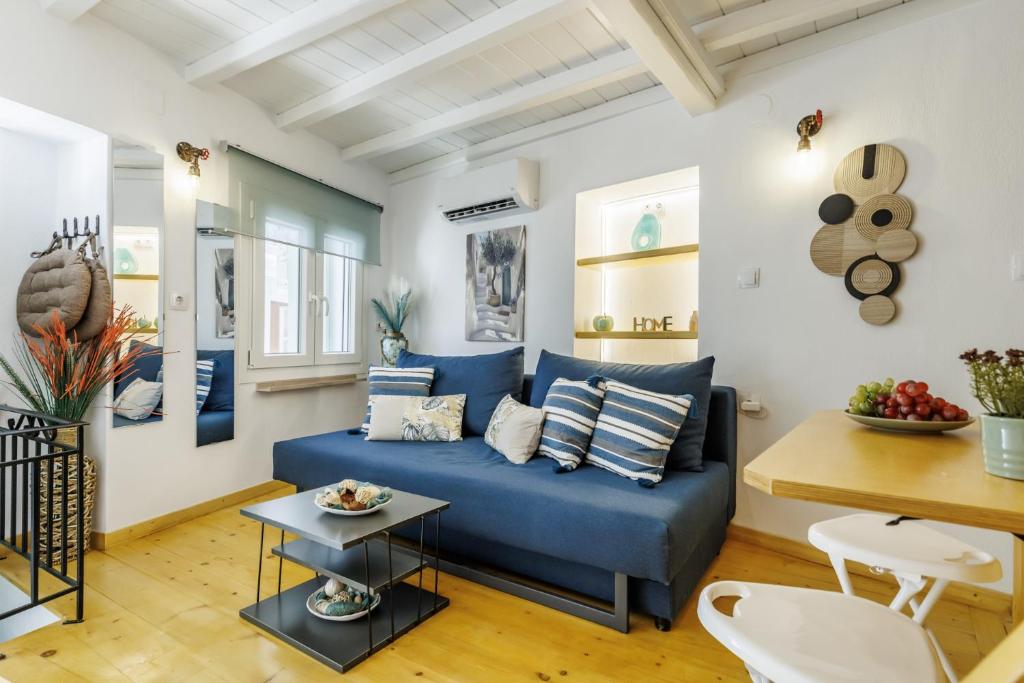 a living room with a blue couch and a table at Maritina Skopelos Maisonette in Skopelos Town