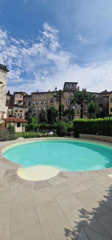 a large blue swimming pool with buildings in the background at Casa Brown - con piscina privata - in Barga