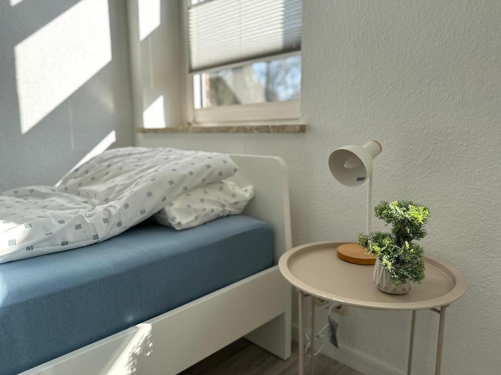 Un dormitorio con una cama con una mesa y una ventana. en Arbeiter - Lounge 1, en Salzgitter