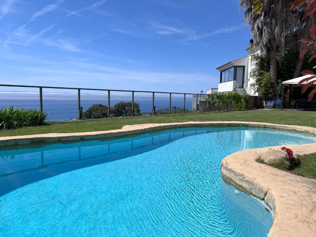 ein Swimmingpool mit Blick auf das Meer in der Unterkunft Villa Oasis Costa Brava in Lloret de Mar