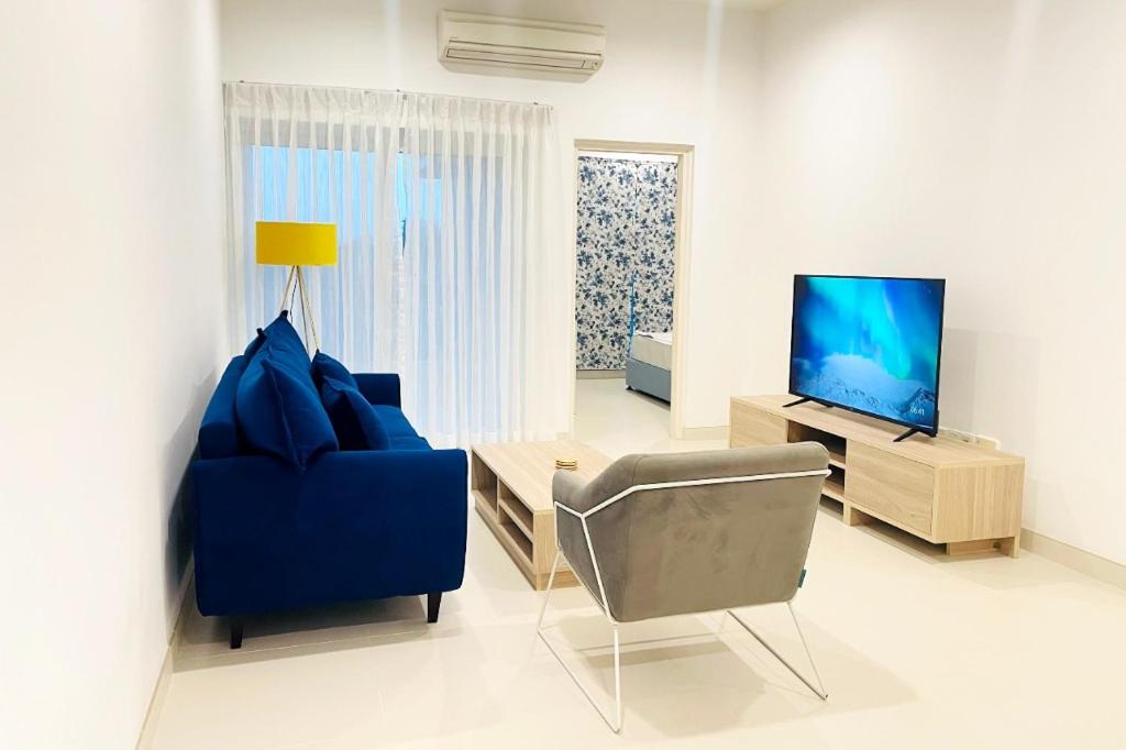 a living room with a blue couch and a tv at Luxury Cozy Apartment - Fairway Galle in Galle