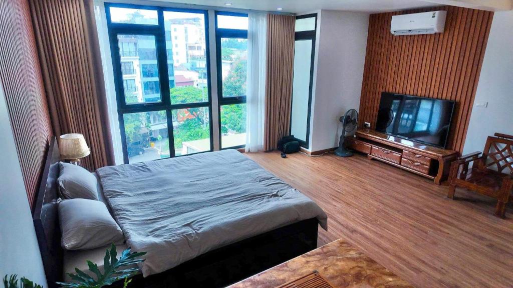 Un dormitorio con una cama y un televisor de pantalla plana. en Midtown home, en Hanói
