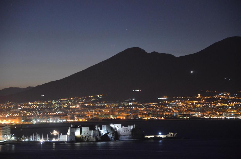 - une vue sur la ville et les montagnes la nuit dans l'établissement Suite 52, à Naples