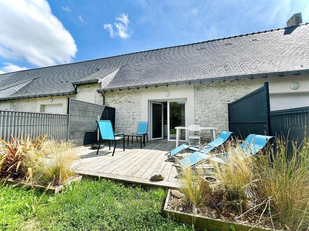 a deck with chairs and a table and a house at Maison calme avec jardin privé, 4 couchages, proche de La Baule - FR-1-245-176 in Saint-André-des-Eaux