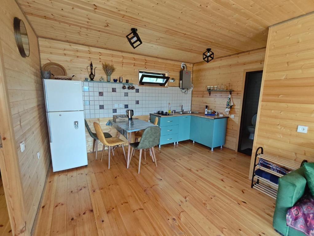 a kitchen with a refrigerator and a table in a room at Qusarion - ქუსარიონი in Agara