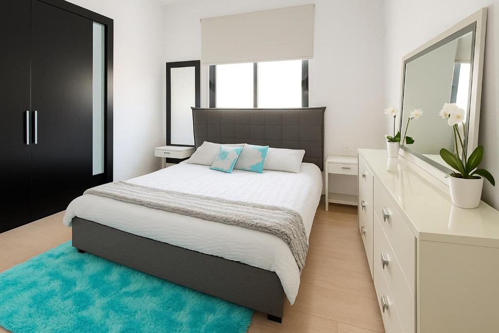 a bedroom with a large bed with a blue rug at Blue Tulip - Strovolos in Kato Lakatamia