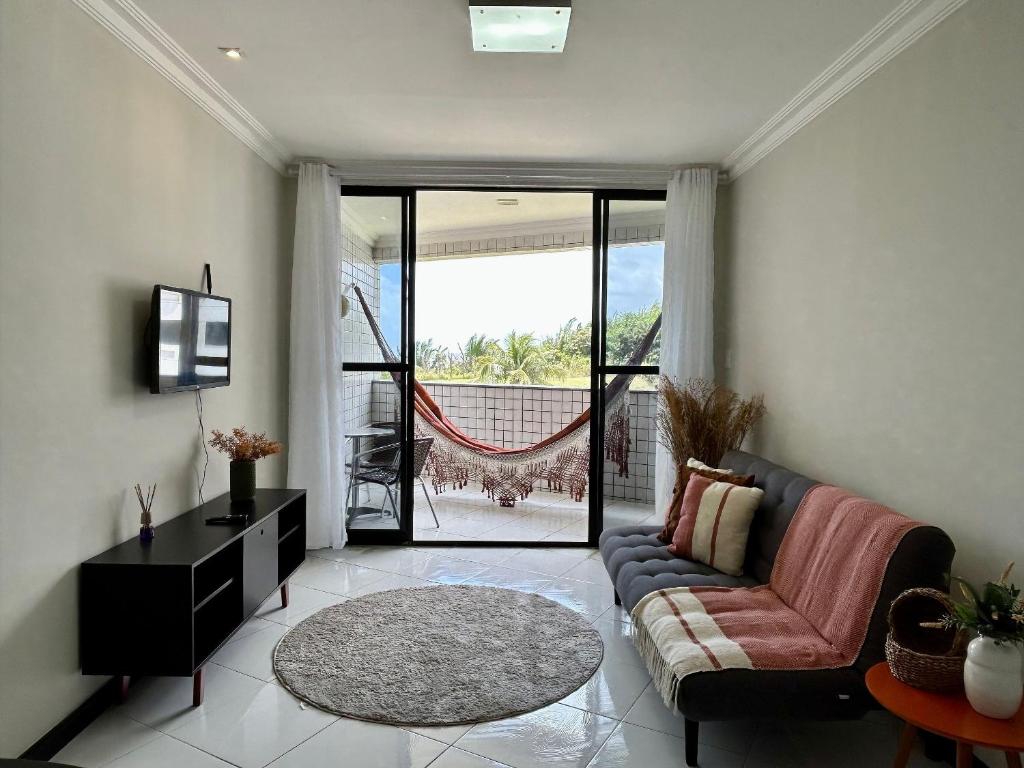 a living room with a couch and a tv at (104) Litorânea Apartment – Steps from the Beach in São Luís