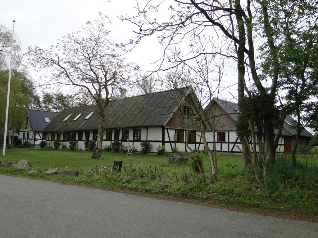 una casa blanca con techo de gambrel en Dyssegaard Holiday Apartment, en Skallerup