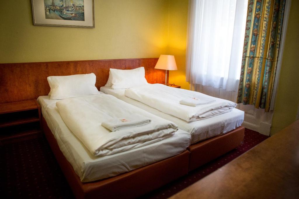 Dos camas en una habitación de hotel con toallas. en City Hotel - HEEFA OHG, en Hamburgo