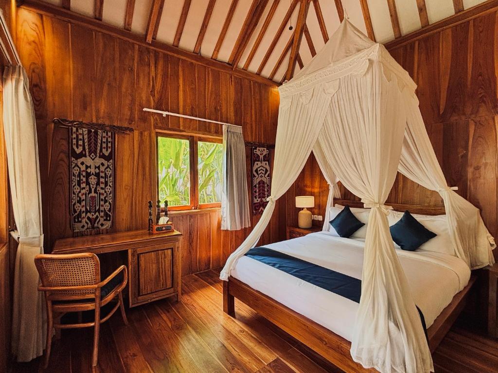 ein Schlafzimmer mit einem Bett mit Moskitonetz in der Unterkunft mata villas gili trawangan in Gili Trawangan