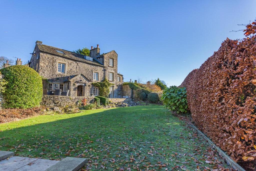 una antigua casa de piedra con un gran patio en Ellesmere House, en Grassington