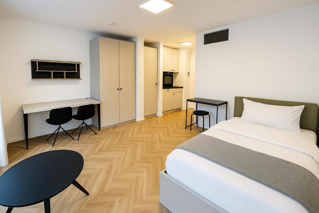 ベルリンにあるSkyline Apartment Adlershof - Premium Design and Full Kitchenのベッドと机と椅子のある寝室