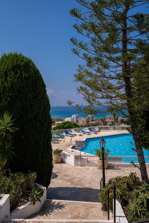 a view of a swimming pool with a tree at Aetheria 3BR in Khlorakas