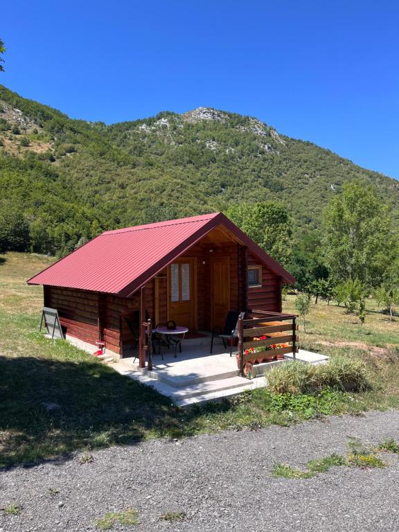 a log cabin with a red roof and a picnic table at Wooden house in Šavnik
