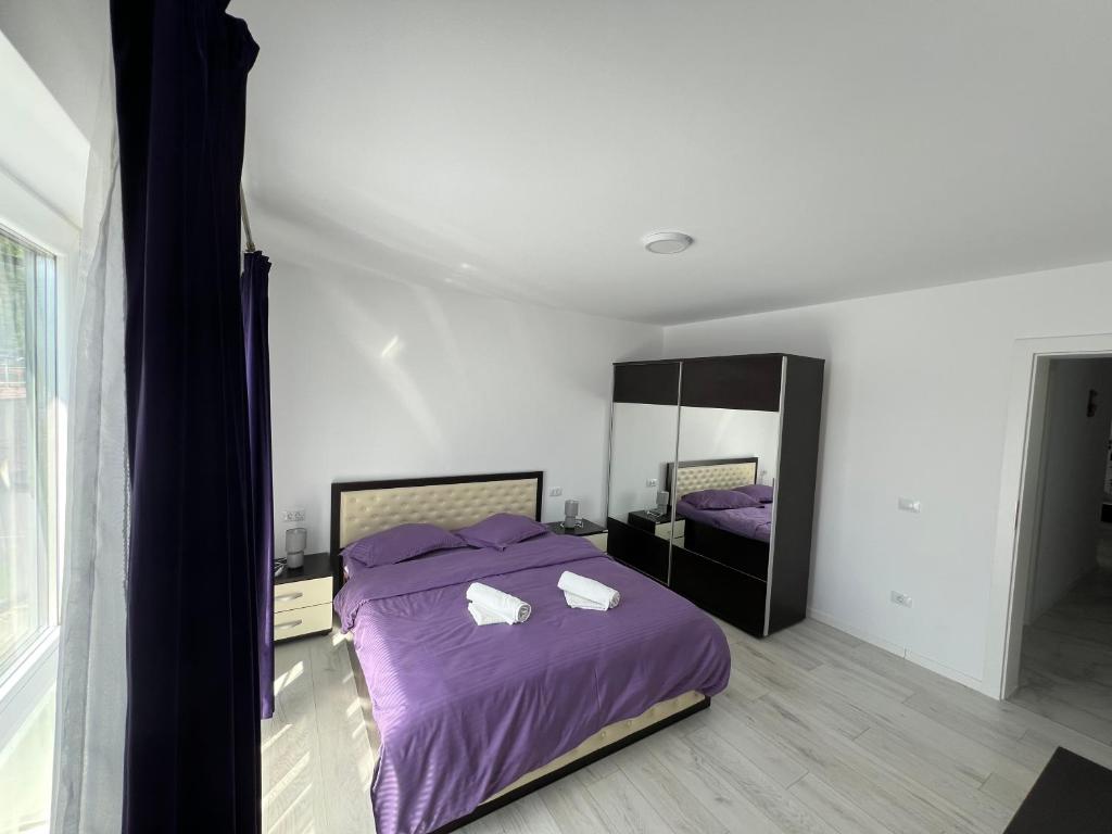 a bedroom with a purple bed and a mirror at Forest View in Câmpulung Moldovenesc