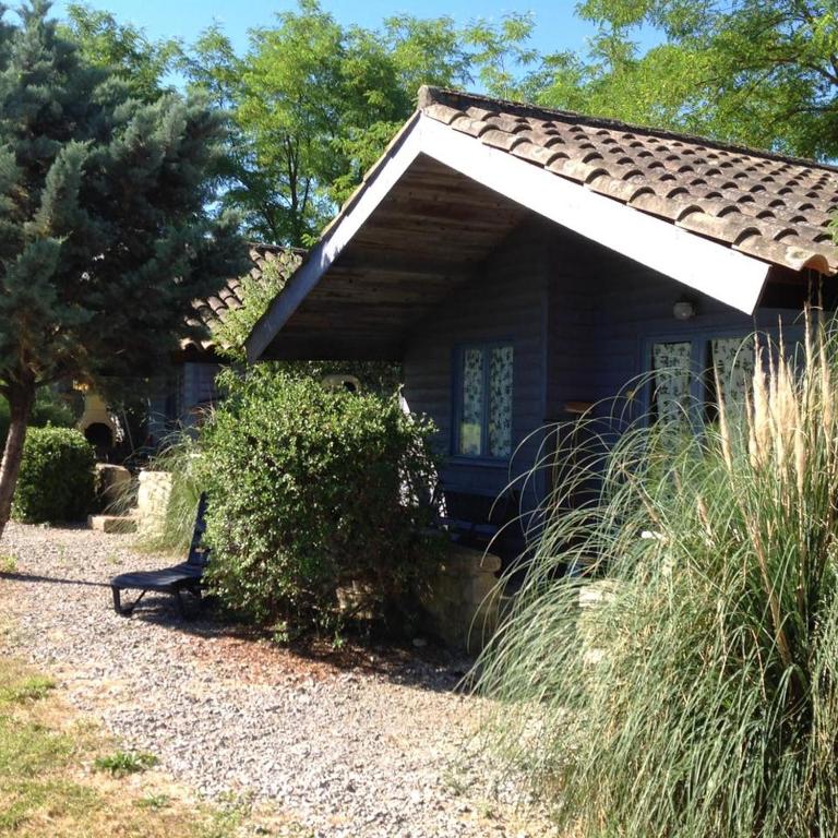 a blue house with a bench in front of it at Chalet #15, 4 pers, Domaine De Ribiere in Grospierres