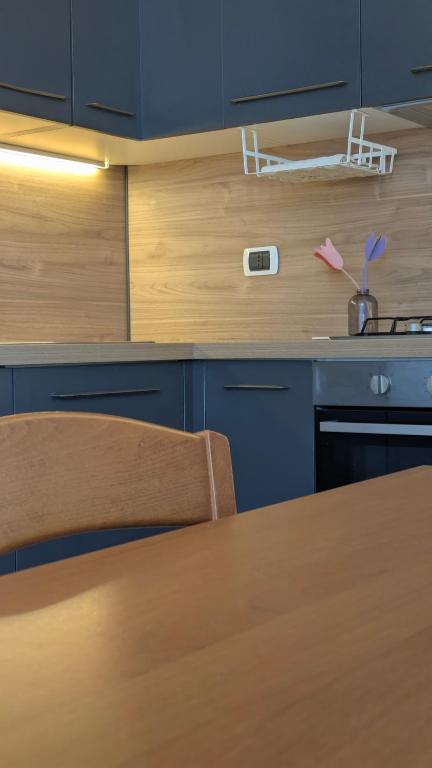 una cucina con armadi blu e tavolo in legno di Cristiana Vacanze a San Benedetto del Tronto