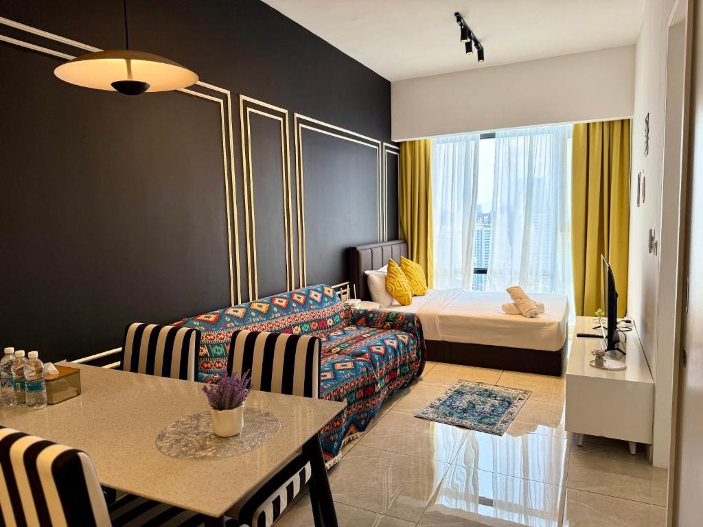 a living room with a couch and a bed at Axon Residence Bukit Bintang by TaheeenS in Kuala Lumpur