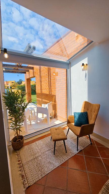a living room with a chair and a patio at Sea Twins Villas in Praia de Mira