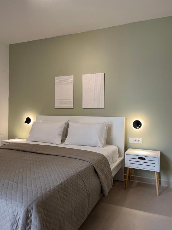 a bedroom with a large bed and a night stand at M P A Luxury Apartment A1 in Agios Nikolaos