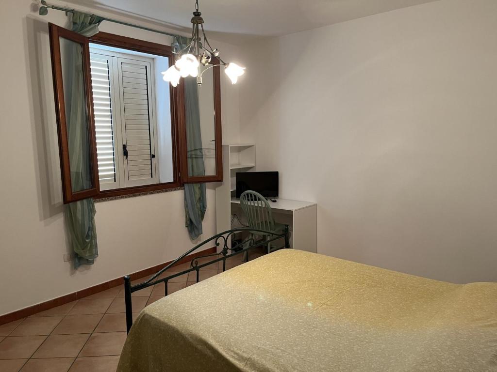1 dormitorio con mesa, espejo y silla en Appartamento " Il tramonto ", en Badesi