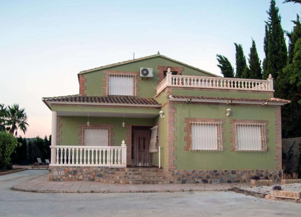 een groen huis met een balkon erop bij Casa rural Cavila in Pliego