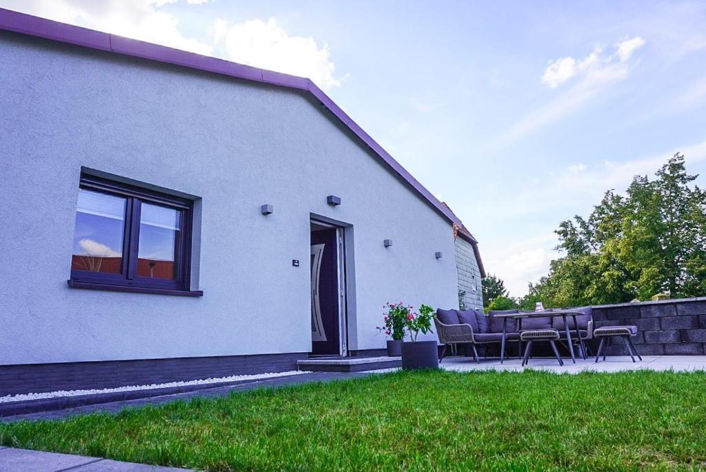 a white house with a table and chairs in the yard at Ferienwohnung Rätzlingen in Rätzlingen
