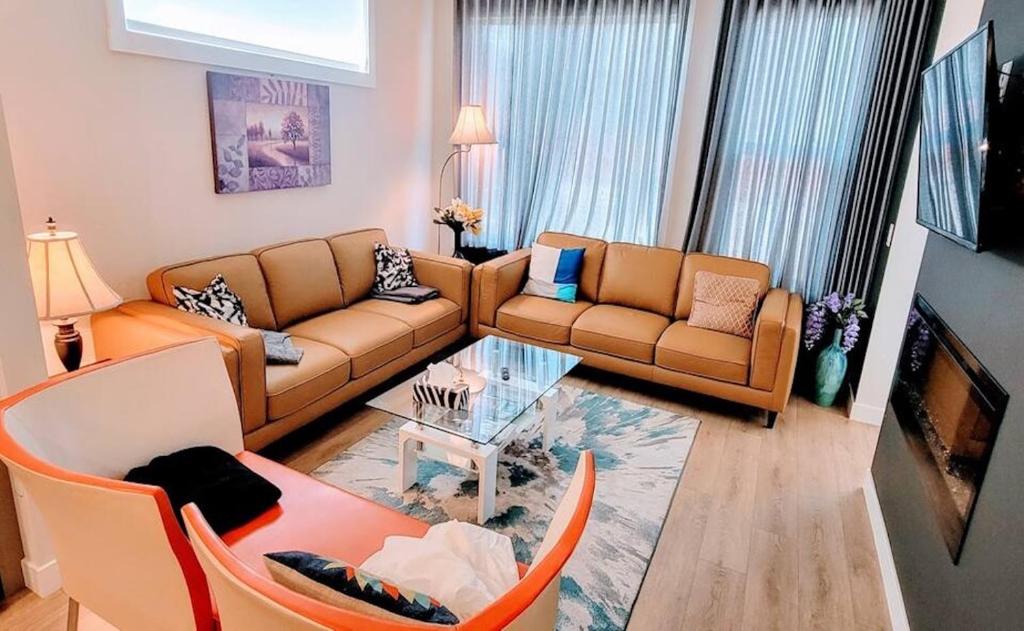 a living room with two couches and a table at Brand New 3-Bedroom Home in a Quiet Neighborhood in Calgary