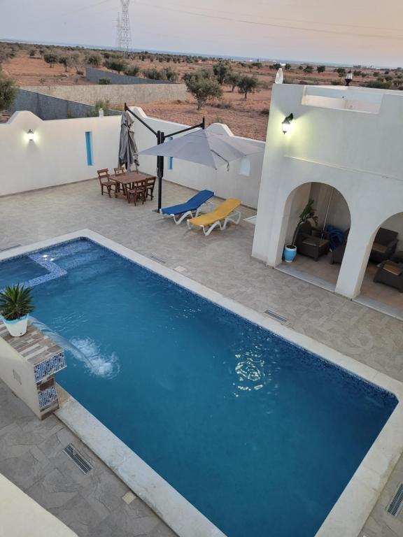 a swimming pool in front of a villa at villa houch serine in Guellala