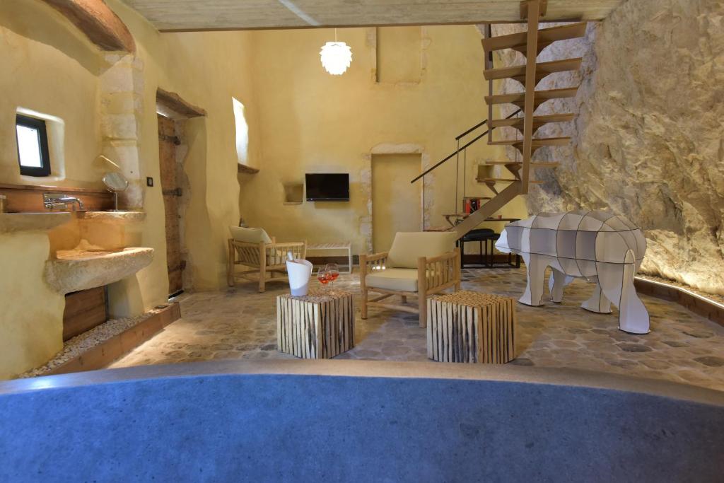a living room with a staircase and a room with a table at Le Silex in Vallon-Pont-dʼArc