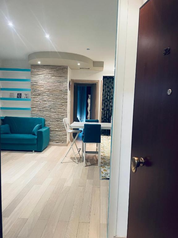 a living room with a blue couch and a table at Airport Flower Home in Marina Julia