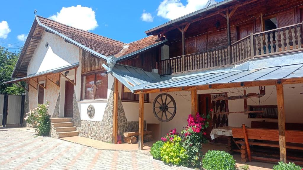 a wooden building with a balcony and flowers at Casa de vacanta Marian in Sâmbăta de Sus