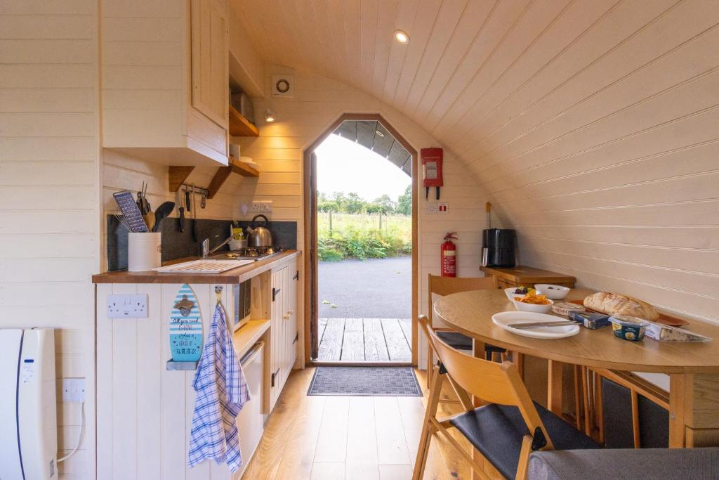 una piccola cucina con tavolo e bancone di Pod3 - Powys River Pods - Pet Friendly Glamping Pod Builth Wells Powys Wales a Garth