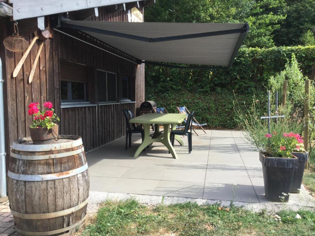 un patio avec une table, des chaises et un parasol dans l'établissement le loft de l'Atelier, à Nans-sous-Sainte-Anne